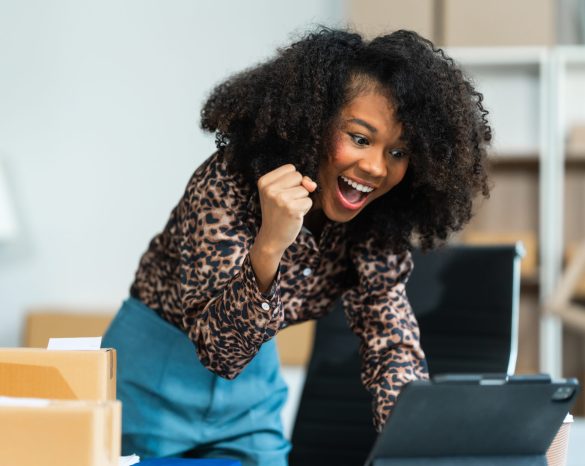 A young African American woman with afro brown hair works in modern office, management clothing